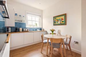 eine Küche mit Tisch und Stühlen in einem Zimmer in der Unterkunft Nordic Regency Apartment in Cheltenham + 23 Fotos