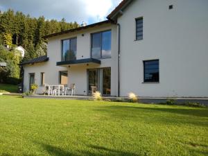 a white house with a lawn in front of it at Apartment Haus Sembachtal in Winterstein