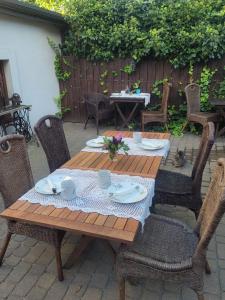 a wooden table with plates and cups and chairs at Babie Lato b&b in Uniejow +43 photos