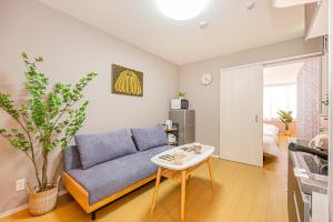 a living room with a blue couch and a table at Mori hotel Akihabara 1 in Tokyo +15 photos