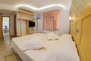 um quarto com 2 camas e lençóis brancos em Hotel Center em Xanxerê