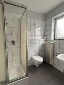 a bathroom with a shower and a toilet and a sink at Case One Monteur Aparthotel in Mülheim an der Ruhr +19 photos