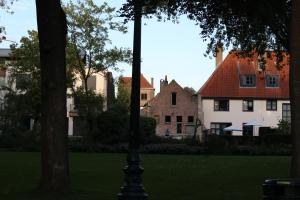 ein Straßenlicht mitten in einem Park mit Häusern in der Unterkunft B&B Koetshuis in Brügge