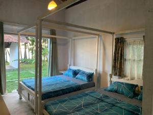 Un dormitorio con dos camas con almohadas azules. en Hill Top House Hiriketiya, en Hiriketiya
