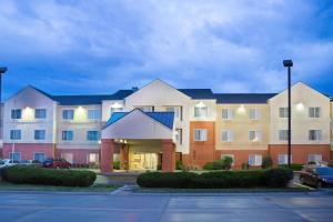 a large apartment building in a parking lot at AmericInn by Wyndham Hays in Hays