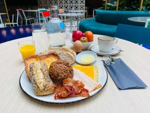 ホーフトドルプにあるThe Florian Amsterdam Airport, WorldHotels Craftedのテーブルの上に盛り付けられた朝食用の皿
