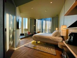 ホーフトドルプにあるThe Florian Amsterdam Airport, WorldHotels Craftedのベッドと大きな窓があるホテルの部屋