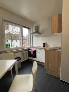 a small kitchen with a table and a sink and a window at Case One Monteur Aparthotel in Mülheim an der Ruhr