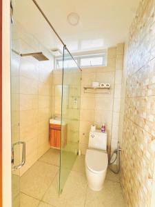 a bathroom with a toilet and a glass shower at Dylan's Penthouse in San Fernando +33 photos