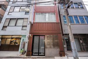 a building with a red facade on a city street at Mori hotel Akihabara 1 in Tokyo