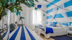 a blue and white bedroom with two beds at L'Approdo in San Leone