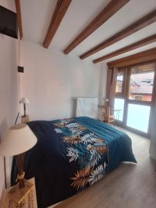 a bedroom with a bed with a blue comforter at L'Horizon du Vignoble in Wangen