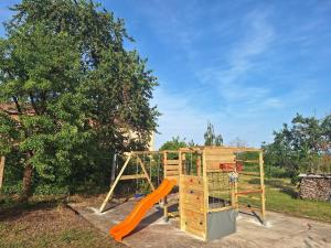 a playground with an orange slide and a basketball hoop at L'Horizon du Vignoble in Wangen