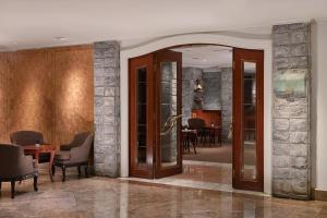 a lobby with wooden doors and chairs and a table at Grand Hyatt Taipei in Taipei