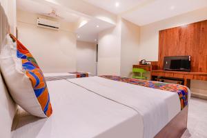 加姆布FabExpress Utsav Residency - Nr Panvel Railway Station的配有床和书桌的酒店房间