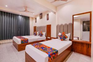 加姆布FabExpress Utsav Residency - Nr Panvel Railway Station的有两张床和一面镜子的卧室