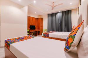 加姆布FabExpress Utsav Residency - Nr Panvel Railway Station的有两张床和一张书桌的卧室