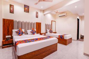 加姆布FabExpress Utsav Residency - Nr Panvel Railway Station的一间房间里有两张床的卧室