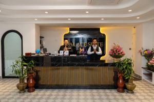 two men standing at a bar in a lobby at Palace Suite Residence in Phnom Penh