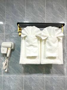 a couple of white towels on a rack in a bathroom at Palace Suite Residence in Phnom Penh