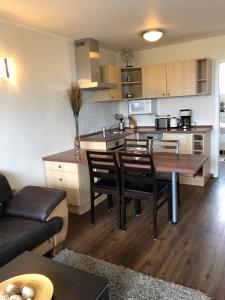 a kitchen and living room with a table and chairs at Maris Ferienwohnung Nr 46 EG mit Terrasse in Scharbeutz