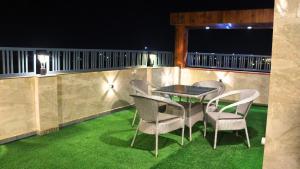 un gruppo di sedie e un tavolo su un balcone di notte di Skymax hotel a Nuova Delhi