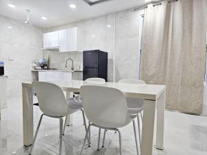 a kitchen with a white table and chairs at Amethyst Hoandedhdhoo in Kaadedhdhoo Airport