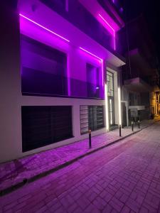 a building with purple lights on the side of it at Adas Aura - Boutique Apartments in Old Town Thessaloniki in Thessaloniki