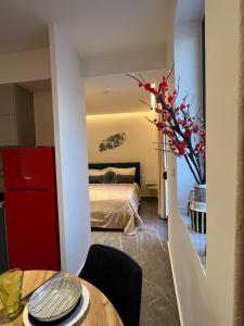 ein Schlafzimmer mit einem Bett und einem Tisch mit einer Blumenvase in der Unterkunft Adas Aura - Boutique Apartments in Old Town Thessaloniki in Thessaloniki