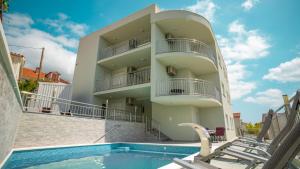 a building with a swimming pool in front of it at La Perla Adriatica apartments Trogir-Seget in Seget Vranjica