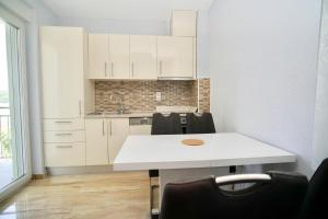 a kitchen with white cabinets and a white counter top at La Perla Adriatica apartments Trogir-Seget in Seget Vranjica