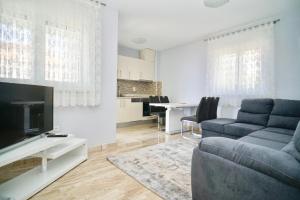 a living room with a couch and a tv at La Perla Adriatica apartments Trogir-Seget in Seget Vranjica