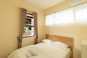 a small bedroom with a bed and a window at Family Only Spacious Hill View Villa - De Reiz Zakir Syariah 5BR in Ciburial