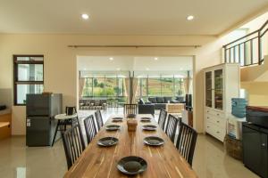 a dining room with a wooden table and chairs at Family Only Spacious Hill View Villa - De Reiz Zakir Syariah 5BR in Ciburial +13 photos