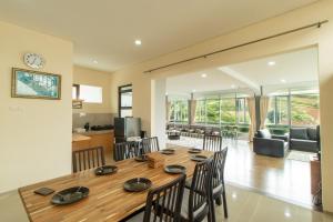 a dining room and living room with a table and chairs at Family Only Spacious Hill View Villa - De Reiz Zakir Syariah 5BR in Ciburial