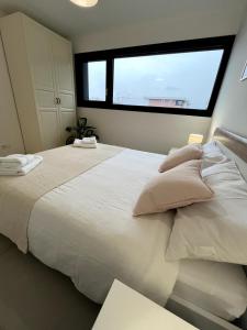 a bedroom with a large white bed with a window at Locarno Center - Casa Incanto - Free Parking & Washer in Locarno