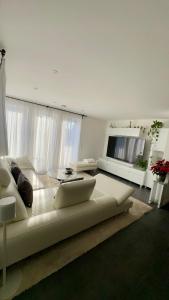 a living room with a white couch and a television at Auszeit im Heinental in Wildberg