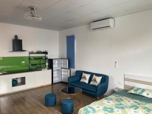 a bedroom with a bed and a blue chair at Hanoi AMD Housing - CH dịch vụ chuẩn khách sạn tại số 2 ngõ 402 Ngô Gia Tự có VAT in Long Biên