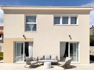 een huis met stoelen en een bank ervoor bij Villa Centenary Goose in Korčula