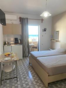 Un dormitorio con una cama y una mesa y una cocina. en Soula Apartments & Studios, en Palaiochóra