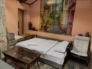 a bedroom with a bed and a chair and a painting at Elit BonRe in Romny