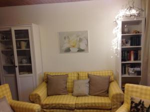 a living room with a yellow couch with pillows at Schwarzwaldhut in Häusern