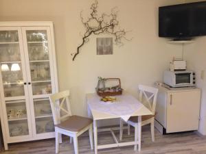 a dining room with a table and chairs and a tv at Schwarzwaldhut in Häusern