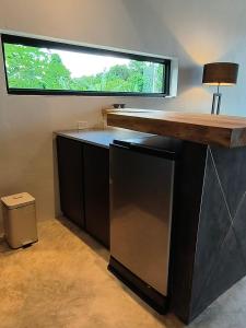 a kitchen with a counter with a window above it at Sky Lofts Airport Phuket in Ban Sakhu