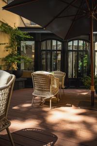 a patio with chairs and a table and an umbrella at Hôtel Le Walt by Inwood Hotels in Paris