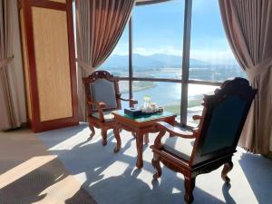a room with two chairs and a table and a large window at Rex Hotel - by BAY LUXURY in An Nhơn