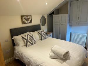 a bedroom with a large white bed with pillows at The Stable -Plymouth in Plymouth
