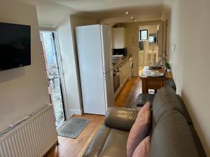 a living room with a couch and a kitchen at The Stable -Plymouth in Plymouth