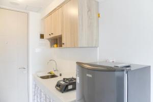a kitchen with a stainless steel refrigerator and a sink at Simply Look and Homey Studio Tokyo Riverside PIK 2 Apartment By Travelio in Rawalembang