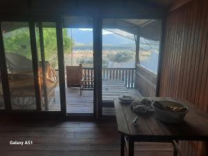 a wooden porch with a table and a view of a deck at Ali dede in Kusadası +7 photos